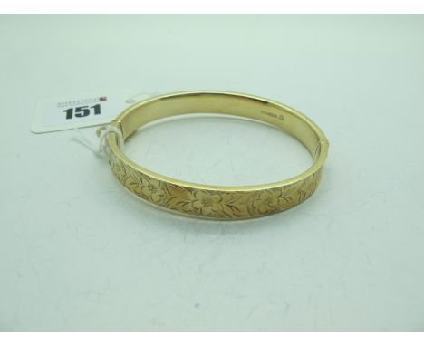 A 9ct Gold Bangle, allover floral engraving, to snap clasp, and safety chain (12 grams).