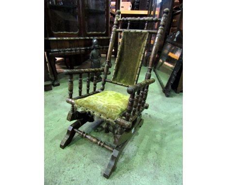 A traditional American rocking chair, child's size, with turned spindle mouldings, carpet seat and back