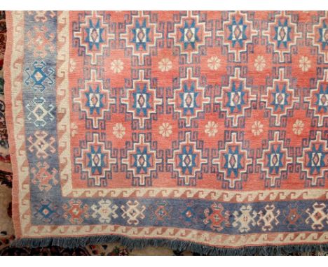 Soumak chain stitch carpet with brick red field, multi geometric panel detail within running borders, 240cm x 150cm