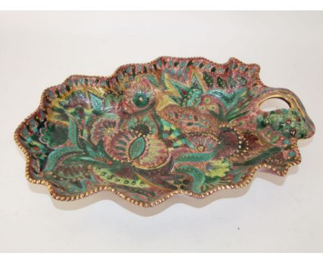 An unusual Belgian art pottery single handled dish of leaf shaped form with shaped rim and polychrome painted stylised floral