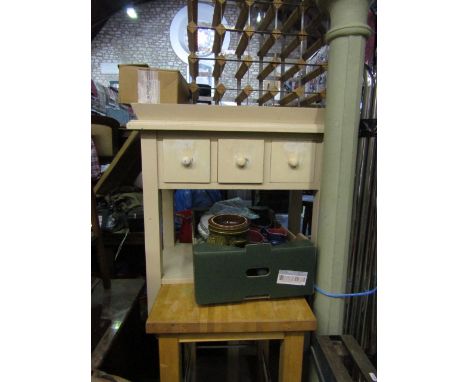 A contemporary kitchen work table raised on four square cut supports with stainless steel under gallery, a further rectangula