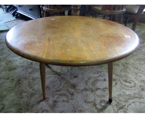 A vintage Ercol light elm and beechwood occasional table of circular form raised on simple splayed and turned tapered support