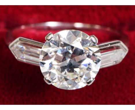 An impressive certificated three stone diamond ring, central stone an early round brilliant cut diamond measuring 9.03mm x 9.