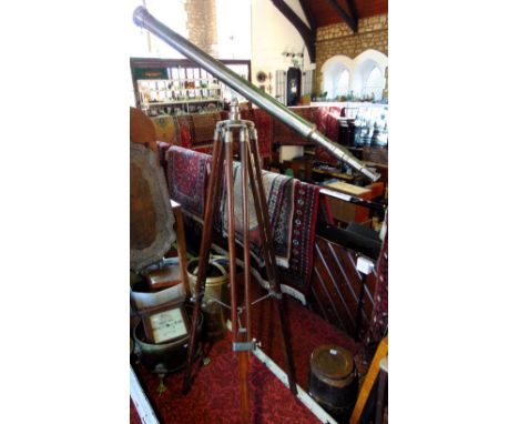 A contemporary chrome telescope upon a  telescopic tripod wooden stand