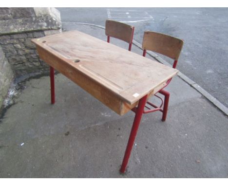 A vintage school desk with two fitted chairs raised on steel framework