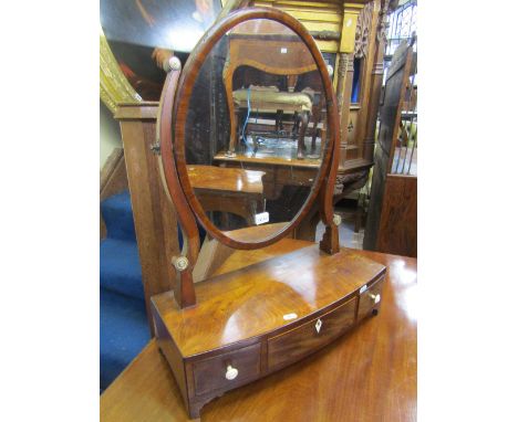 A Georgian mahogany toilet mirror the oval mirror plate raised on a bow fronted base fitted with three drawers on bracket sup