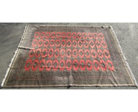 An Afghan wool carpet with pale pink ground, multi repeating geometric medallions, set within running borders, 300cm x 220cm 