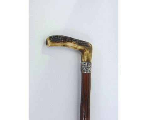 A primitive walking stick with silver collar and horn handle