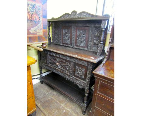 An old English oak buffet with a central frieze drawer and open shelf below, the raised back with column supports, with overa
