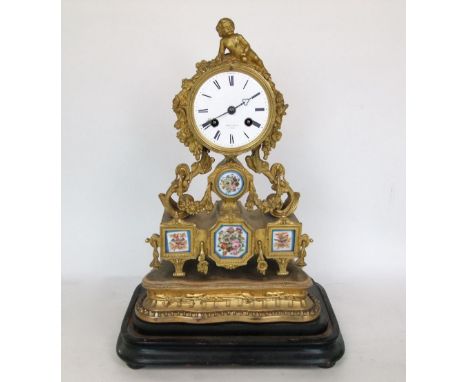 Good quality French ormolu two train figural drum head mantle clock, mounted by a recumbent cupids, raised upon floral scroll