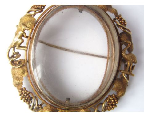 An Australian portrait brooch with openwork frame interspersed by grape vines and applied kangaroo and emu figures, possibly 