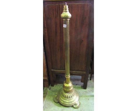 A Victorian brass lamp standard with partially reeded column, the domed disc shaped platform base and flattened feet