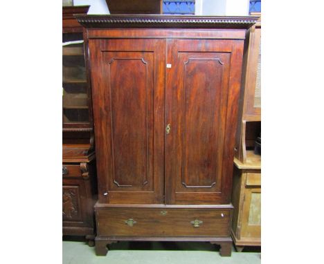 A Georgian mahogany hanging cupboard with moulded and dentil cornice over a pair of three quarter length rectangular panelled