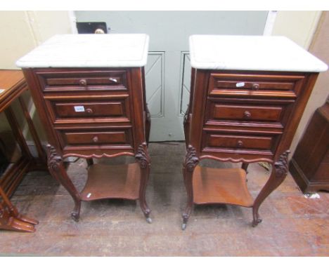 A pair of 19th century mahogany bedside or lamp tables with marble tops, the front elevation enclosed by three drawers (2 dum
