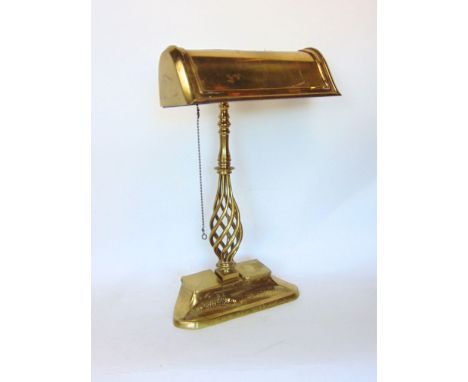 A good brass bankers light, with typical long arched shade upon an open barley twist column and base fitted with two ink well