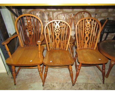 A set of six elm and beechwood Windsor hoop and stick back dining chairs with central pierced wheel splats and saddle shaped 