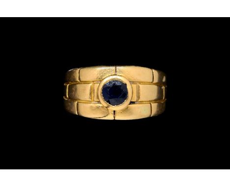 A CARTIER SAPPHIRE RINGThe central round faceted sapphire, in a rub over setting, within a brick link design, size N, in 18 c