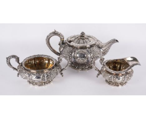 A GEORGE IV SILVER THREE PIECE TEA SETComprising; a teapot, a twin handled sugar bowl and a milk jug, each piece with floral,