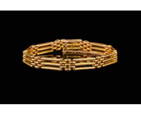 AN EDWARDIAN GATE BRACELET IN 15 CTwith tongue and clip clasp and safety chain, stamped 15 ct, gross weight 12.8 grams.Condit