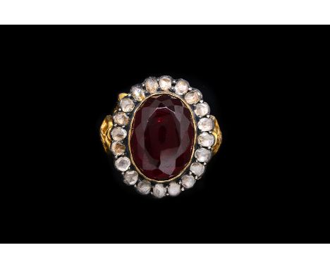 A 19TH CENTURY DIAMOND AND GARNET ECCLESIASTICAL RINGCollet set with the oval cut garnet within a surround of silver set rose