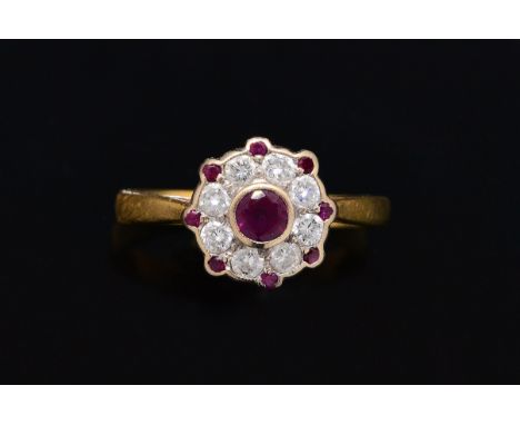 AN RUBY AND DIAMOND CLUSTER RINGCollet set with the circular cut ruby at the centre, in a surround of eight circular cut diam