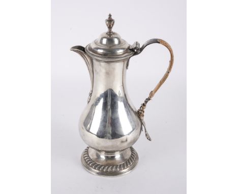 A GEORGE III SILVER HOT WATER JUGOf baluster form, decorated with a gadrooned rim, London 1777, gross weight 778 gmsCondition