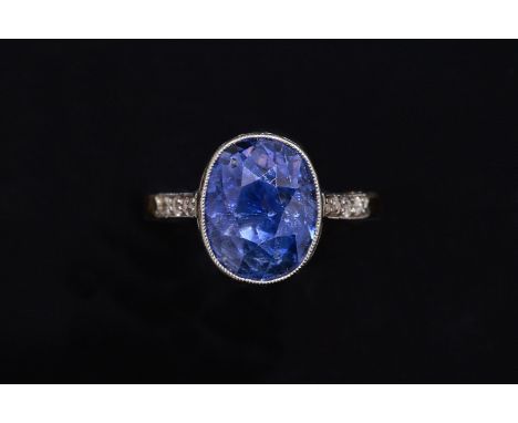 A CEYLON SAPPHIRE AND DIAMOND RINGCollet set with the cushion shaped Ceylon sapphire (estimated weight 6 carats) between diam