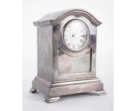 A SILVER CASED MANTEL CLOCKFitted with a brass movement, the circular enamelled dial with black Roman numerals, the case rais