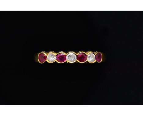 A RUBY AND DIAMOND SEVEN STONE HALF HOOP RINGSet with four round rubies, alternating with three round brilliant cut diamonds,