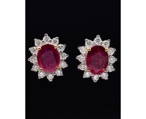 A PAIR OF RUBY AND DIAMOND CLUSTER EARRINGSEach claw set with the oval cut ruby in a surround of twelve circular cut diamonds