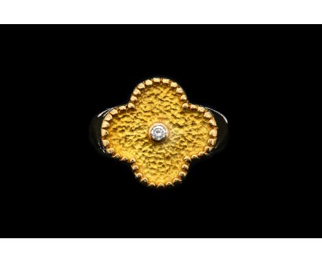 A VAN CLEEF AND ARPLES DIAMOND ALHAMBRA RINGWith a textured gold finish and with a round brilliant cut diamond to the centre,