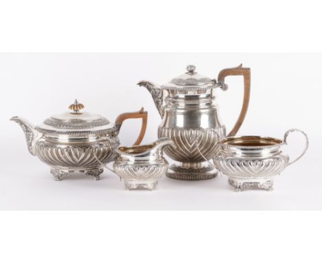 A SILVER THREE PIECE MATCHED TEA SET AND A SILVER HOT WATER JUG (4)The three piece tea set comprising; a teapot with a wooden