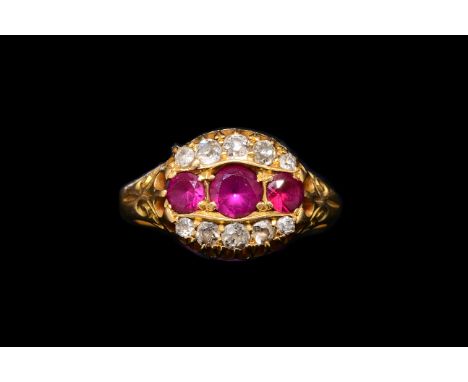 AN EDWARDIAN RUBY AND DIAMOND RINGSet with three round cut rubies and ten old mine cut diamonds, in a claw setting, with scro