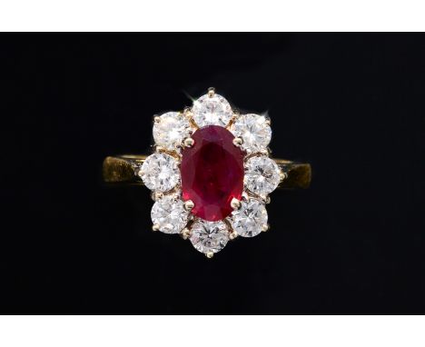 A RUBY AND DIAMOND CLUSTER RINGSet with a oval faceted ruby, estimated weight 1.31 carats, surrounded by a halo of eight roun