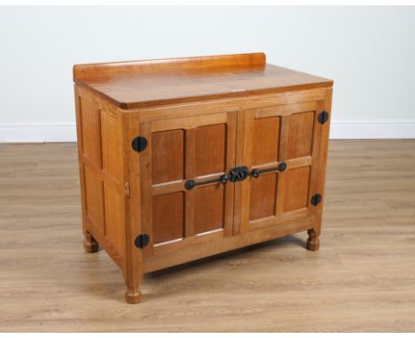 ROBERT MOUSEMAN THOMPSON OF KILBURN; AN ADZE OAK PANELLED TWO DOOR SIDE CABINET ON OCTAGONAL FEET92cm wide; 51cm deep; 81cm h