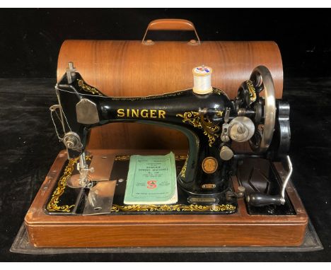 A Singer manual sewing machine, domed wooden carry case, with accessories 