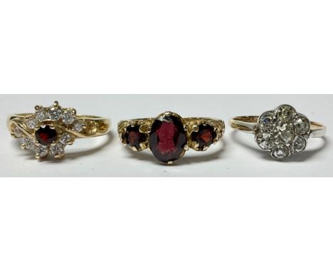 A 9ct gold ring, set with three garnets, size M, marked 375, 2.7g; a 9ct gold and silver paste cluster ring, size K/L, 2.2g; 