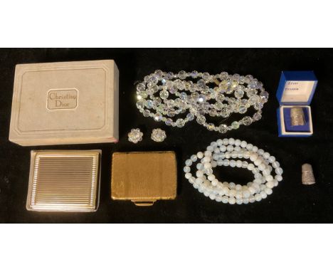 A Christian Dior compact, soft pouch, boxed; another powder compact as a suitcase; a single strand of opalite polished beads;