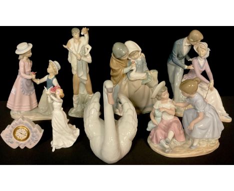 A Lladro figure, Boy with Goat, number 4506, 28cm; a Lladro model of a swan, number 5231; a Lladro miniature mantel clock, 7.
