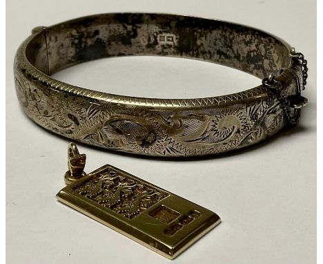 A 9ct gold Three Lions pendant, marked 375, 8.2g; a silver hinged bangle, 20g (2) 