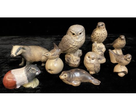A Purbeck Pottery model of a badger 20cm wide, another; a Poole model of an owl, modelled by B Lindley-Adams, signed; a simil