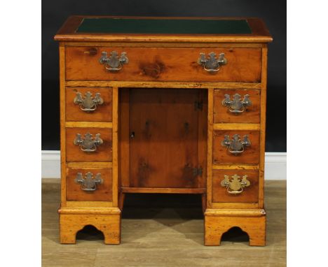 A George III style yew veneer and mahogany kneehole desk, rectangular top with inset writing surface above an arrangement of 