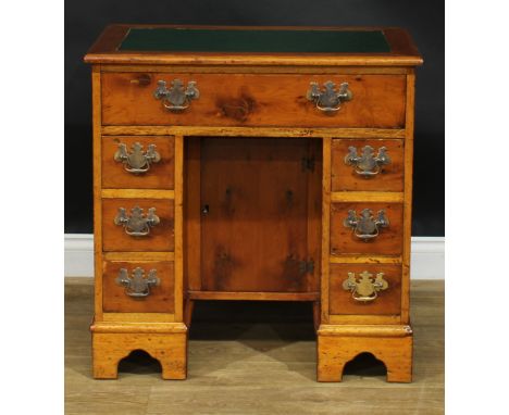 A George III style yew veneer and mahogany kneehole desk, rectangular top with inset writing surface above an arrangement of 