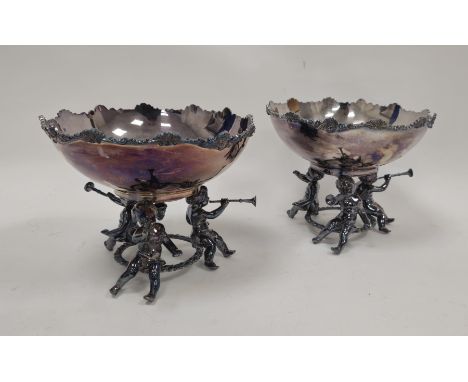 Pair silver-plated pedestal bowls, each with scroll and shell border, on three putto supports, each playing a horn, 24cm diam