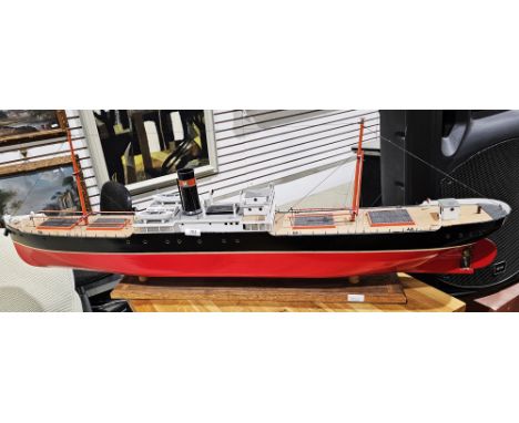 Early to mid 20th century model of a tramp ship steamer, named 'Darwin', with red painted hull, on wooden stand with accompan