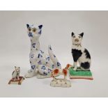 Late 19th century Staffordshire pottery model of a black and white cat seated on a green cushion,