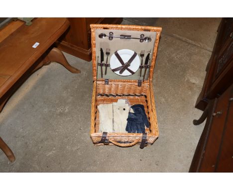 A wicker picnic hamper together with a bag of lady's gloves