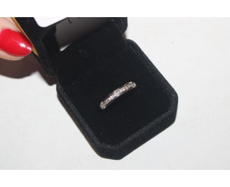 A white metal half eternity ring set with white stones, ring size P/Q