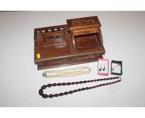 A wooden desk top jewellery box and contents of various costume jewellery to include dress ring, brooches and necklaces