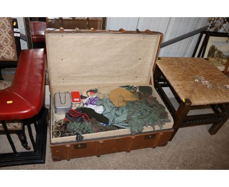 A wooden and leather bound trunk with contents of miscellaneous military related items 